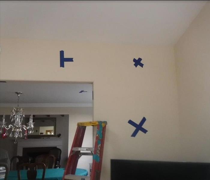 Blue tape marking water damage in a home.